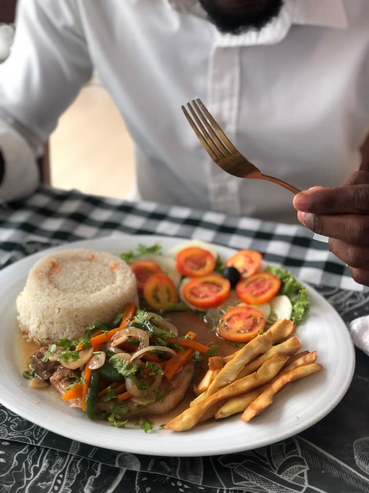 Prato Casa dos Paladares com arroz, carne, salada de tomate e batata frita servido em mesa.